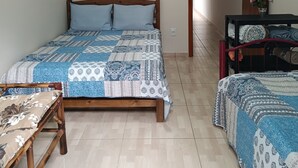 A bedroom with a wooden bed, a small table, and a bench.
