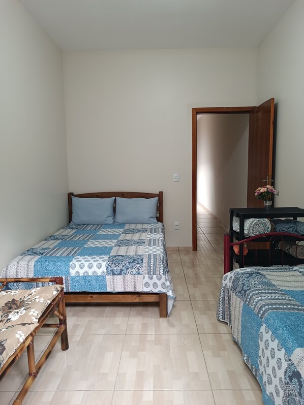 A bedroom with a wooden bed, a small table, and a bench.