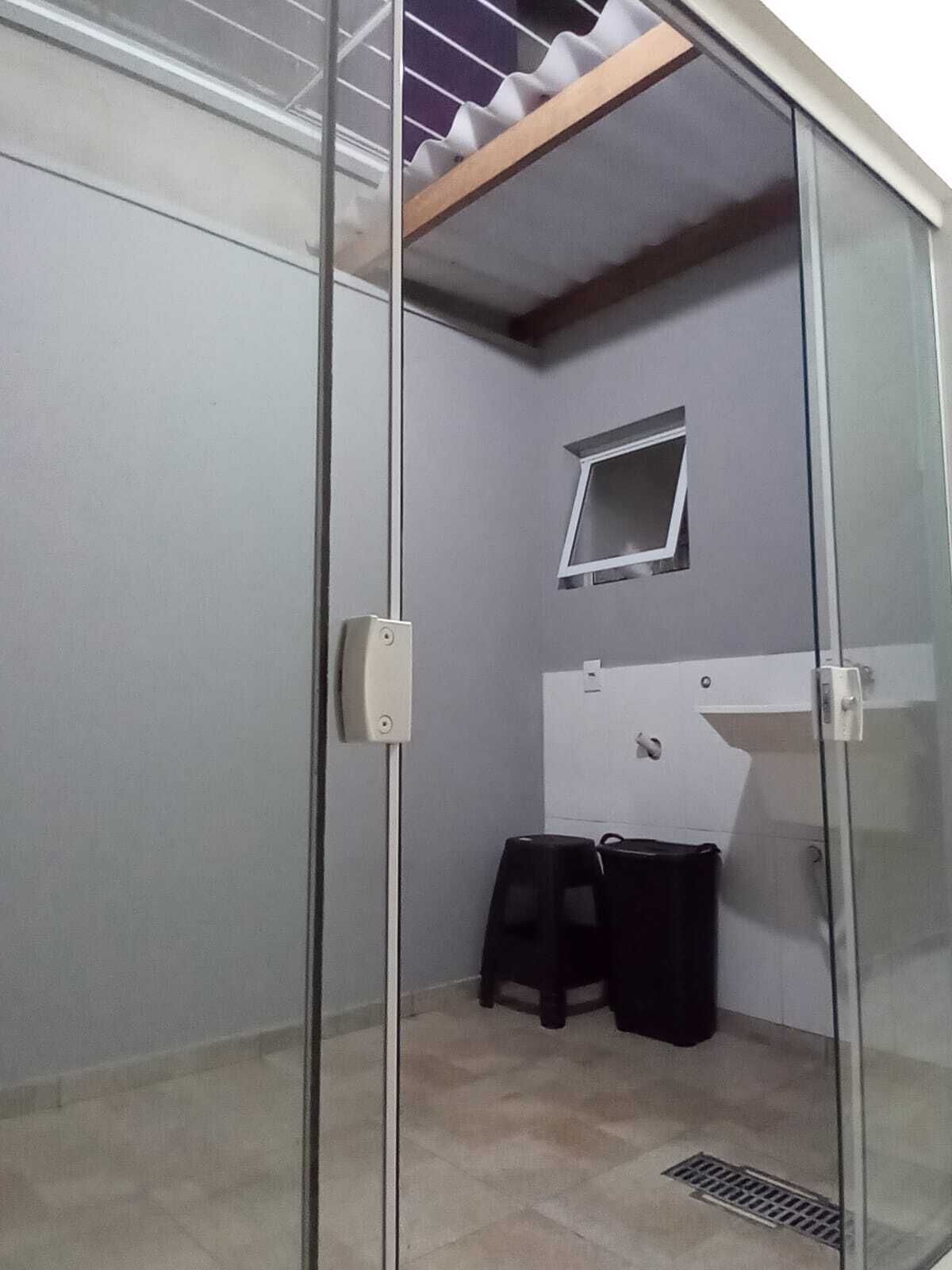 A room with a sliding glass door, a small window, a whiteboard, and two black trash bins.