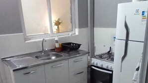 A compact kitchen with a sink, stove, and refrigerator.