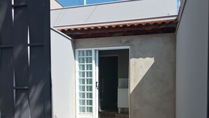 A small, enclosed patio area with tiled flooring and a door leading to a room.