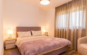 Restful retreat with a large bed, bedside tables, and a comfortable chair.
