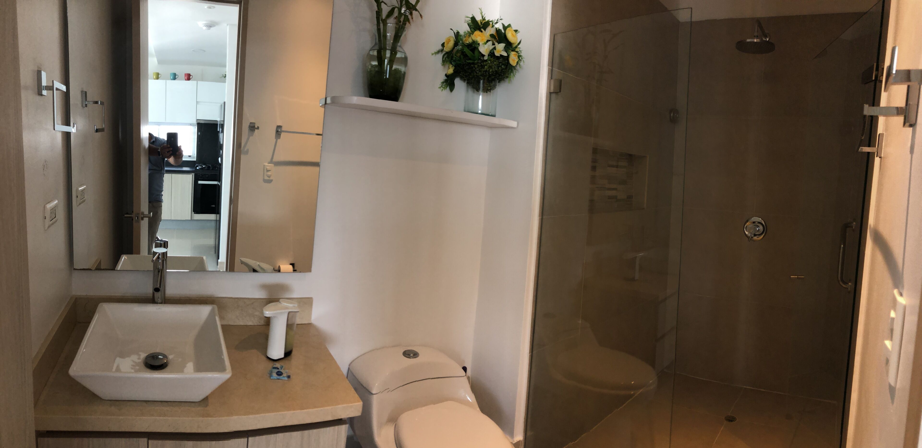 A bathroom with a sink, toilet, and glass-enclosed shower.