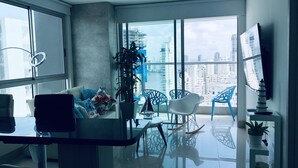 A modern living room with a large window, a sofa, a coffee table, and a potted plant. - MURANO ELITE  GRADIMAR (Cartagena)
