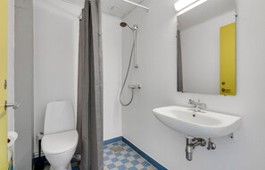 A bathroom with a toilet, a shower, and a sink. - Fanø Bad, værelse 26 (Fanø)
