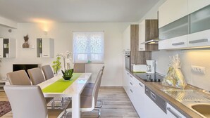 A modern kitchen with white cabinets, a wooden countertop, and a built-in oven.