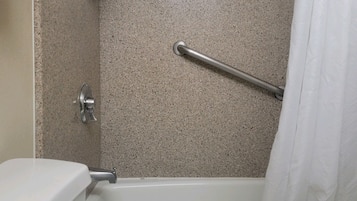 Un baño con ducha, inodoro y toallero.