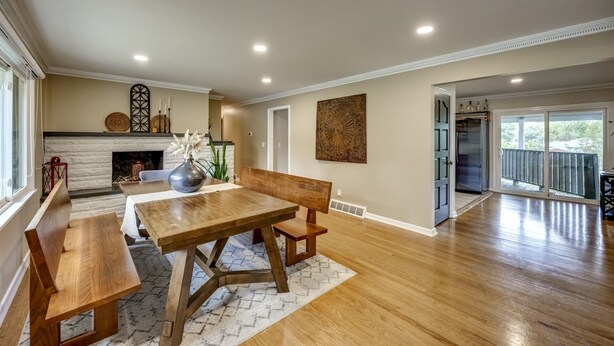 A spacious living area with a wooden dining table, benches, and a fireplace. - Quiet Comfort: 5 BR & 2.5 BA, 6 TVs, Pet Friendly (Radcliff)