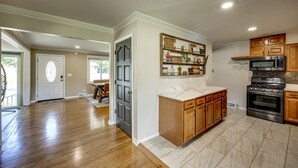 A spacious kitchen with wooden cabinets, a built-in microwave, and a stainless steel oven. - Quiet Comfort: 5 BR & 2.5 BA, 6 TVs, Pet Friendly (Radcliff)
