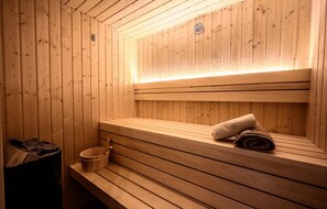 Una sauna de madera con bancos y un calentador de banco.