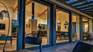 Un interior moderno con grandes puertas de cristal que dan a un comedor y una cocina.