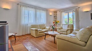 A living room with two beige leather sofas, a wooden coffee table, and a TV on a stand. - Gorgeous home in Pula (Pula)