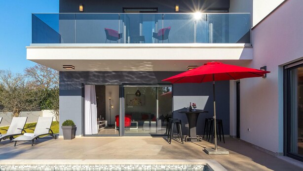 A modern two-story house with a glass balcony, a swimming pool, and outdoor seating. - Lovely home in Liznjan (Liznjan)