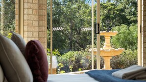 A bedroom with a large window overlooking a garden and a fountain. - Whale Watch Family & Pet Friendly Augusta Retreat (Augusta)