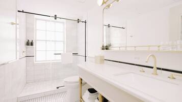Une salle de bain moderne dotée d’un grand miroir, de deux vasques et d’un espace douche.