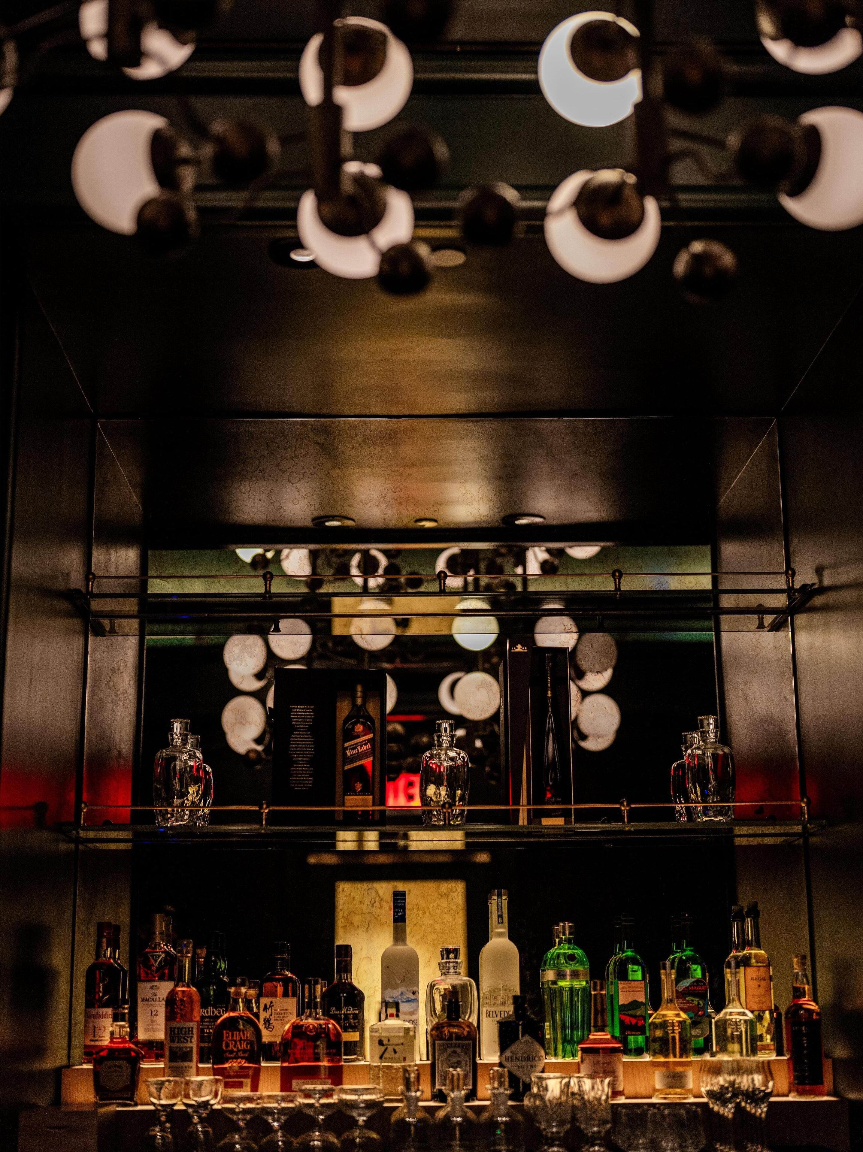 A bar area with shelves of liquor bottles and glasses.