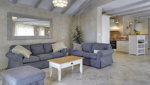 A living room with two grey sofas, a small white coffee table, and a large mirror on the wall.