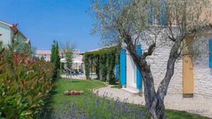 A courtyard with a pool, outdoor seating, and a stone wall.