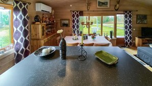 Una cocina amplia con una isla grande, armarios de madera y vistas al exterior.