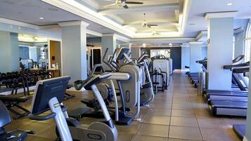 Ein Fitnessstudio mit Laufbändern, Crosstrainern und Gewichtbänken.