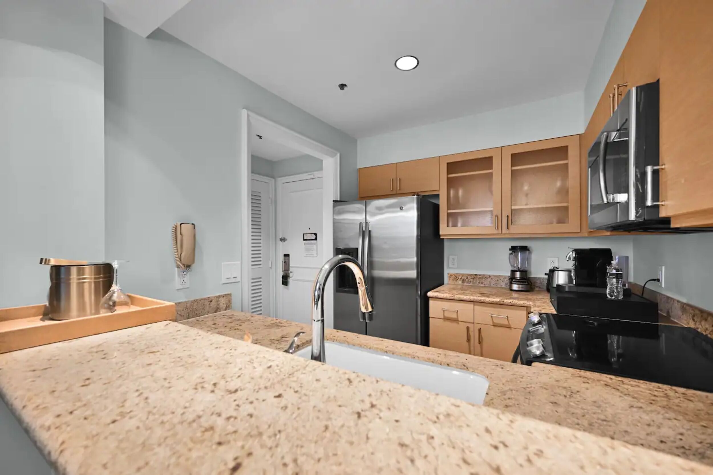 A modern kitchen with granite countertops, stainless steel appliances, and wooden cabinets.