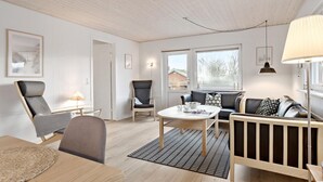 A modern living room with a wooden ceiling, a sofa set, a dining table, and a view through the windows. - Amazing home in Haderslev with WiFi (Haderslev)