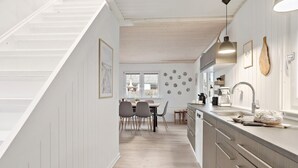 A modern kitchen with a dining area, wooden flooring, and a staircase. - Amazing home in Haderslev with WiFi (Haderslev)