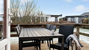An outdoor wooden deck with a table and chairs, a view of neighboring houses, and a clear sky. - Amazing home in Haderslev with WiFi (Haderslev)