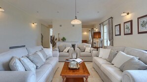 Ein geräumiges Wohnzimmer mit zwei Sofas, einem Holztisch und einem Kamin.