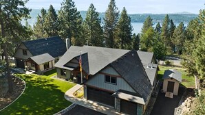 A residential area with multiple houses, a well-maintained lawn, and a lake in the background.