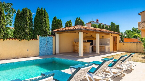 A poolside area with lounge chairs, a barbecue area, and a covered patio. - Beautiful home in Marcana (Marcana)