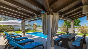 A covered outdoor area with a pool, lounge chairs, and a table with chairs. - Stunning home in Sveti Petar u Sumi (Sveti Petar u Sumi)