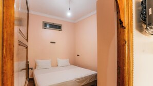 A bedroom with a single bed, wooden flooring, a light switch, and a thermostat on the wall. - The Best Apartments of Ourika Valley (Vallée de l'Ourika)