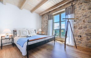 Relax in this serene bedroom with a comfortable bed and a window offering a view of the outdoors.