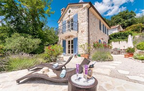 Relax on the balcony with a wicker lounge area, perfect for a romantic evening.