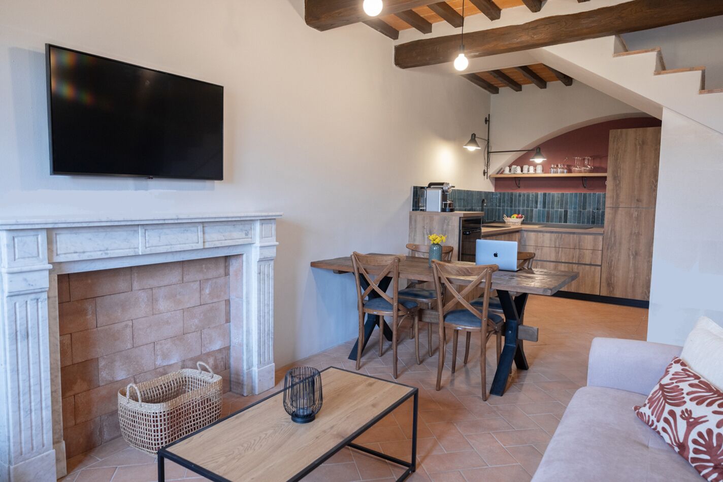 Uma sala de estar moderna com lareira, uma área de jantar e uma cozinha ao fundo.