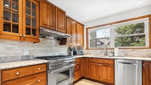 A modern kitchen with wooden cabinets, a stainless steel stove, and a dishwasher. - Downtown, Walk to Main, 1 mile to ski resort (Breckenridge)