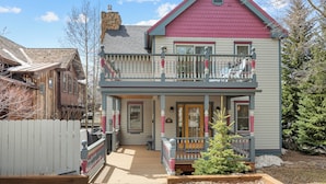 A two-story house with a balcony, a front porch, and a small garden area. - Downtown, Walk to Main, 1 mile to ski resort (Breckenridge)