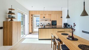 Una cocina moderna con armarios de madera, una isla central e iluminación colgante.