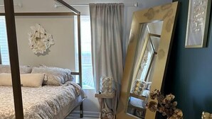 A bedroom with a four-poster bed, a large mirror, a fluffy rug, and a vase with dried flowers. - Baltimore Beauty! Johns Hopkins! Private Parking! (Baltimore)