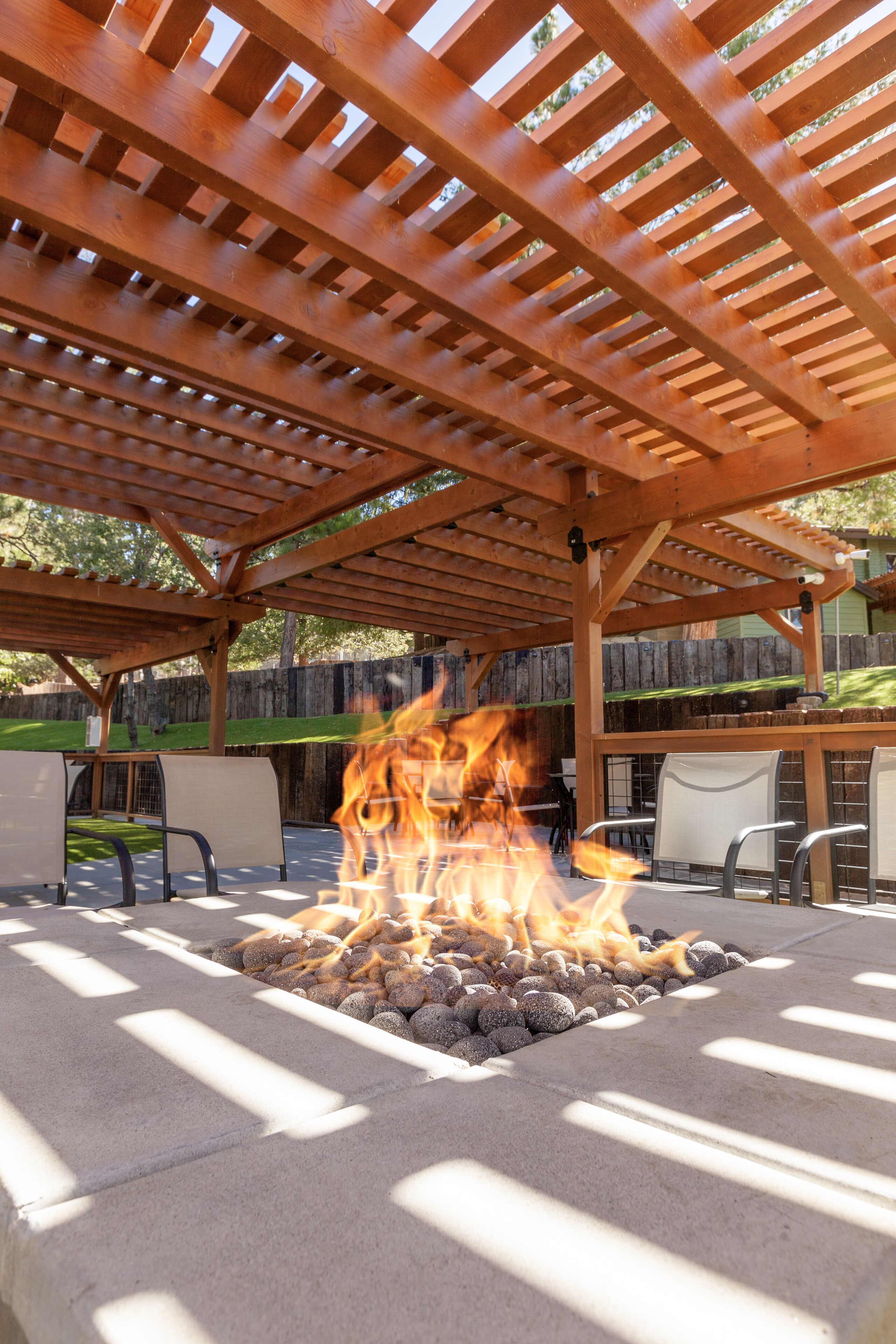 A covered outdoor area with a fire pit surrounded by seating.