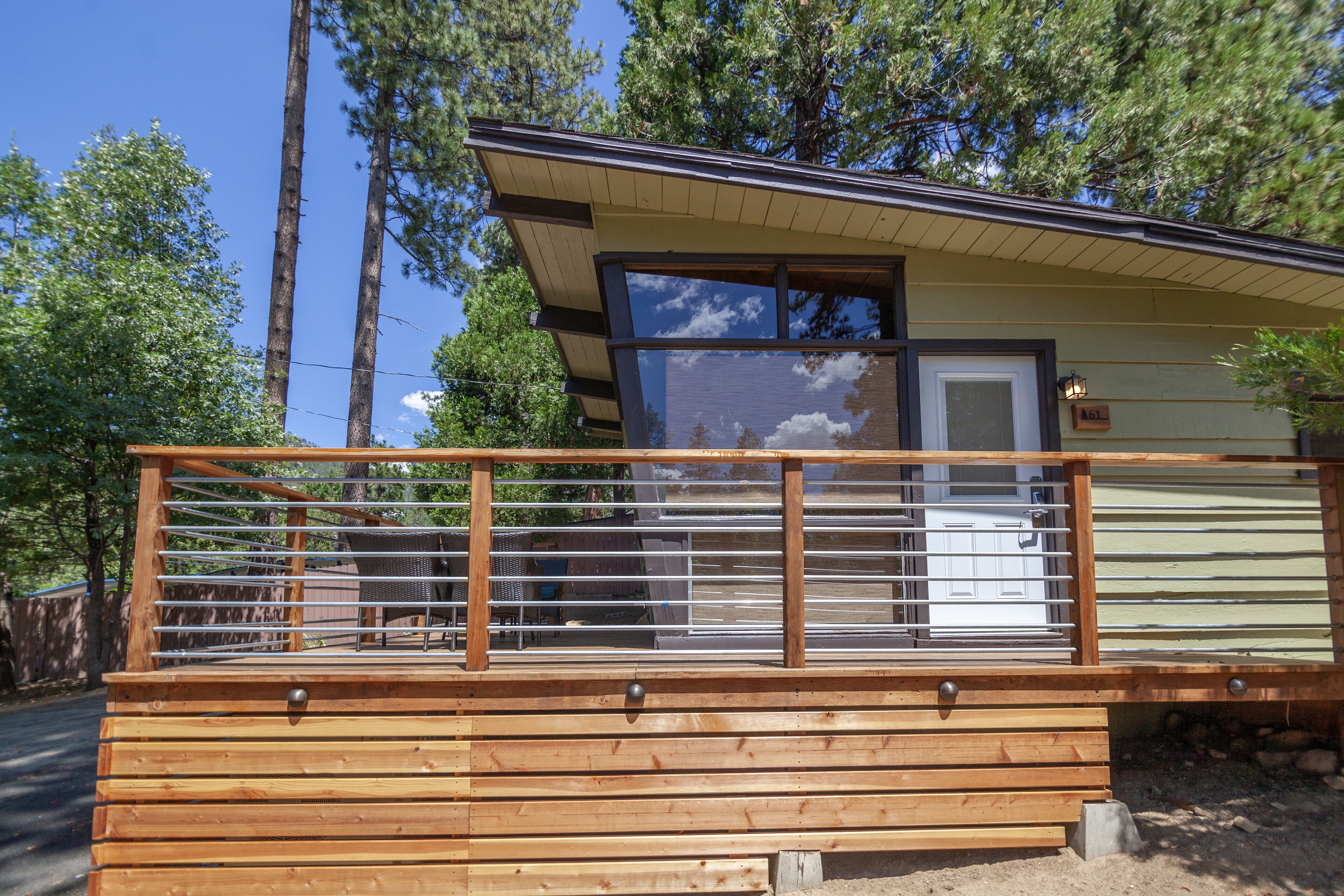 A cabin with a wooden deck, a window with a view, and a door.