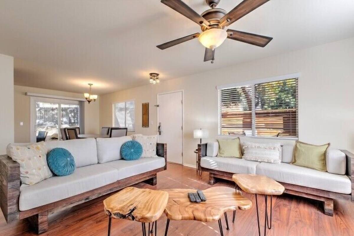 A living room with two sofas, a wooden coffee table, and a ceiling fan.