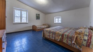 A room with two beds, a wooden wardrobe, and two windows. - Orbetello Giannella Apartment (Orbetello)