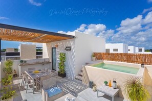Enjoy a tranquil retreat on the rooftop, surrounded by lush greenery and a small pool.