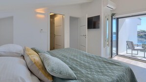 A bedroom with a bed, a TV, a balcony with a chair, and a view of the sea. - Gorgeous home in Pula (Pula)