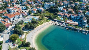 An aerial view of a coastal town with a sandy beach, residential buildings, and a marina. - Beautiful home in Pula (Pula)