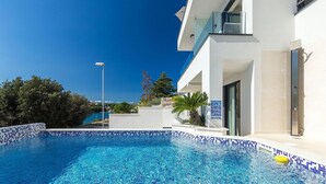 A modern hotel with a swimming pool, a clear view of the sea, and a balcony with a glass railing. - Beautiful home in Pula (Pula)