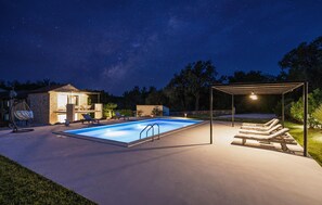 A swimming pool with a pergola and lounge chairs, surrounded by a stone building and trees. - Gorgeous home in Tinjan (Tinjan)