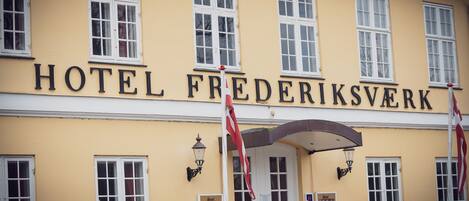 Un edificio con el letrero "HOTEL FREDERIKSVERK" sobre la entrada.